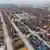 Containerterminal im Hafen von Guangzhou in China - Luftaufnahme mit zahlreichen Kränen an der Küstenseite und großem Platz mit riesiger Menge an gestapelten Containern