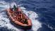 People in life jackets in small boat belonging to Spanish NGO Open Arms People in life jackets in small boat belonging to Spanish NGO Open Arms