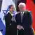 Israeli President Isaac Herzog shakes hands with German President Frank Walter Steinmeier in front of Israeli and German flags at Bellevue Palace in Berlin, Germany