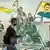 A man walks past a mural depicting supporters of the Syrian Democratic Forces (SDF), one of them raising a flag showing the face of Abdullah Ocalan -- founding member of the militant Kurdistan Workers' Party (PKK) outlawed by Turkey, in Syria's northeastern city of Qamishli on December 16, 2024.