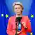 Belgien, Brüssel | EU-Kommissionspräsidentin von der Leyen hält vor einer EU-Flagge ein Mobiltelefon in die Kamera, auf dessen Bildschirm ein QR-Code zu sehen ist