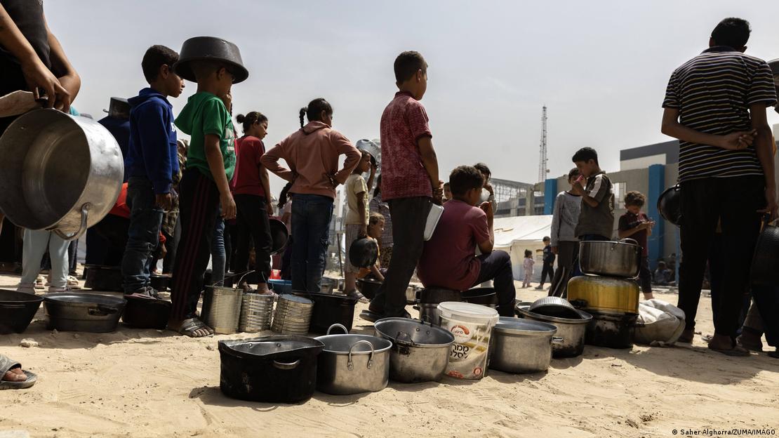 Gazastreifen Gaza-Stadt 2025 | Menschen stehen mit Töpfen und anderen Behältern zur Essensausgabe an