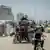 Palestinos desplazados cargan sus pertenecias en bicicletas, motocicletas y otros viejos vehículos.