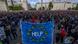 Demonstranci w Budapeszcie trzymają flagę unijną z napisem "Help" Demonstranci w Budapeszcie trzymają flagę unijną z napisem "Help"