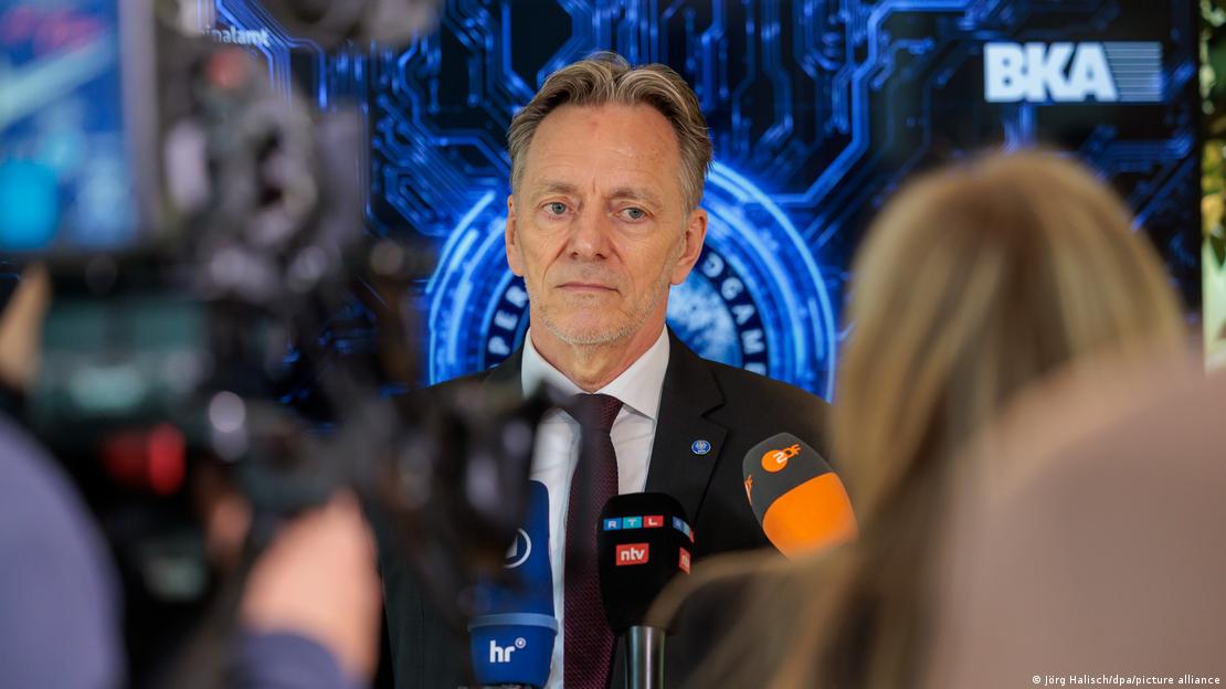 BKA-Präsident Holger Münch steht vor einem in blauen Farben verfremdeten Hintergrund mit dem Kürzel BKA, das für Bundeskriminalamt steht. Zahlreiche Journalistinnen und Journalisten halten ihm Mikrofone entgegen.