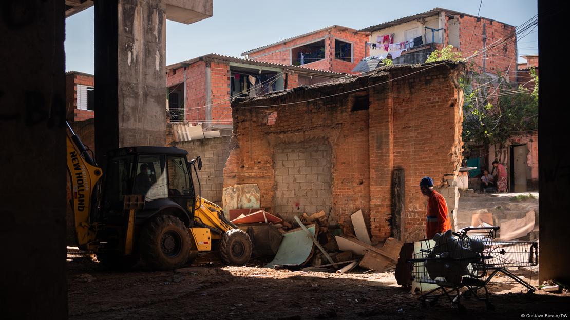 Trator empurra restos de um barraco. Ao fundo, a favela do Moinho Trator empurra restos de um barraco. Ao fundo, a favela do Moinho