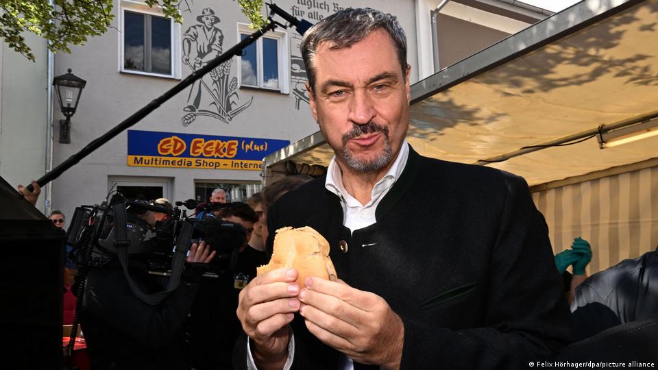 Markus Söder elinde etli sandviçle poz veriyor
