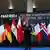 El político habla con detrás las banderas de los países participantes en la reunión y una inscripción en la que se lee, en inglés, "por la implementación de la solución de los dos Estados".