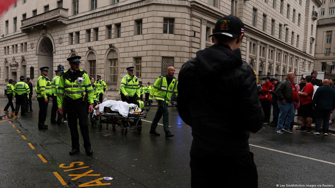 Bir sokakta, sedye ile çok sayıda polis eşliğinde taşınan yaralı