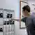 Estudante deposita celular em guarda-volumes numa sala de aula