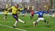 A Real Kashmir player, in yellow, takes a shot while an opponent, in blue, slides to block A Real Kashmir player, in yellow, takes a shot while an opponent, in blue, slides to block