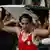 Boxer Imane Khelif holds up the Algerian flag in the ring after a victory in the women's welterweight division at the 2024 Paris Olympics