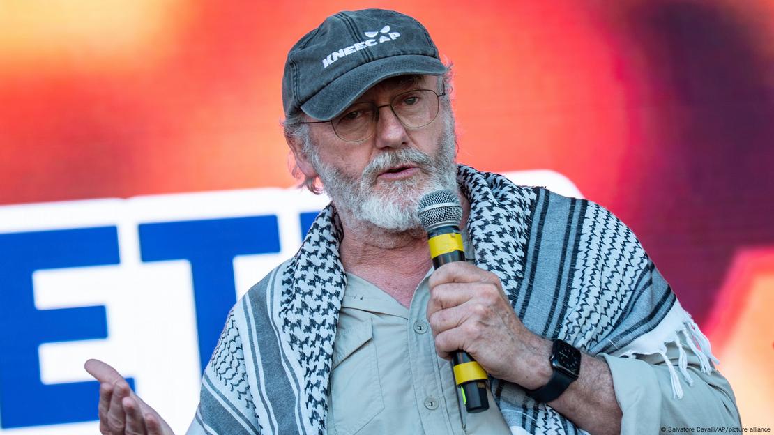 El actor irlandés Liam Cunningham y un simpatizante de la Flotilla de la Libertad conversan durante un acto previo a la partida del Maldeen hacia Oriente Medio, en Catania (Italia).