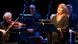 A woman stands and sings in front of an orchestra A woman stands and sings in front of an orchestra