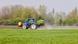 A tractor is seen spraying a field with fertilizer
A tractor is seen spraying a field with fertilizer