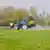 A tractor is seen spraying a field with fertilizer


