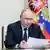 El presidente ruso sostiene un folio mientras mira hacia adelante con semblante serio.
