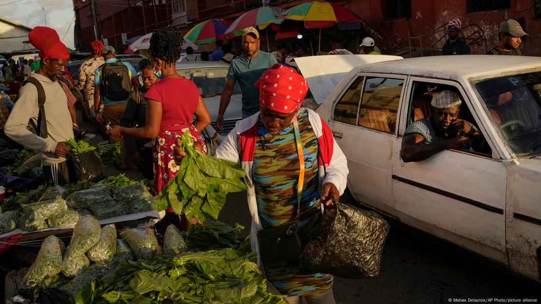 Pessoas comprando verduras em um mercado de rua Pessoas comprando verduras em um mercado de rua