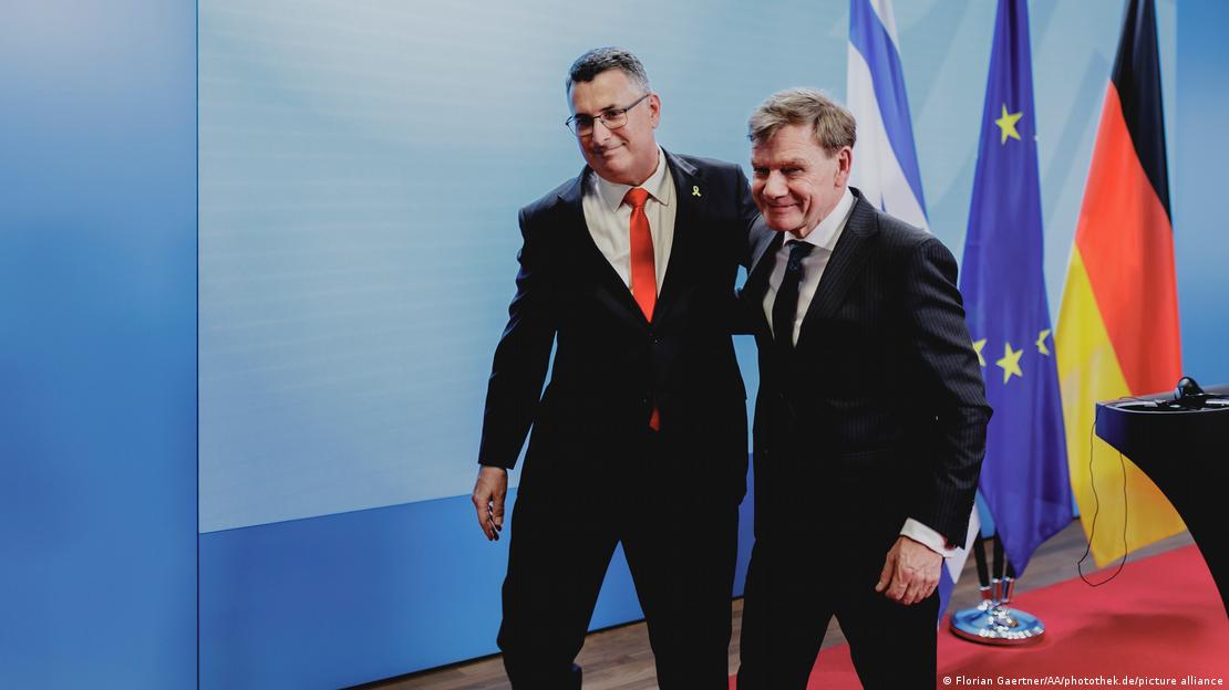 Außenminister Johann Wadephul und Israels Außenminister Gideon Sa'ar Arm in Arm vor Flaggen ihrer Länder und der EU