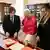 A religious bystander looks on as Argentina's President Javier Milei (left), Pope Leo XIV, (center) and Milei's sister Karina (right) inspect objects on a desk at the Vatican on June 7, 2025.