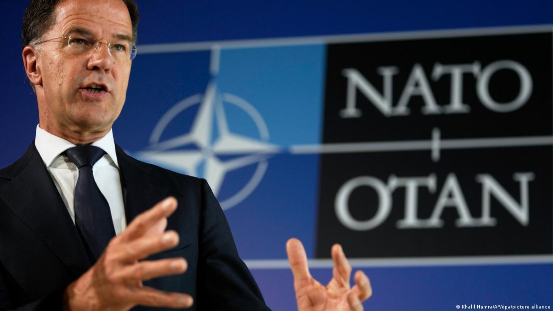 NATO Genel Serketeri Mark Rutte ittifakın logosu önünde açıklama yaparken.