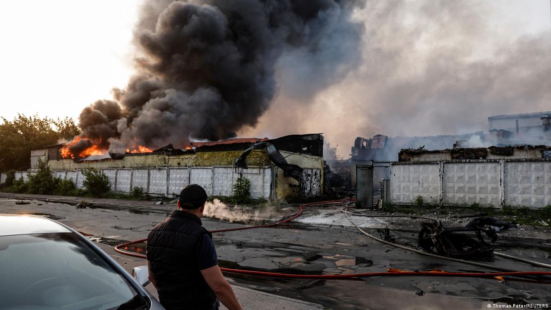 Ein Mann schaut auf brennende Gebäude in der ukrainischen Hauptstadt Kyjiw nach einem Drohnenangriff 