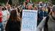 Protestas en Los Ángeles contra la política antimigración de Donald Trump: una mujer porta un cartel que dice: "Extranjeros ilegales" (ambas palabras tachadas), y luego "Amigos, vecinos, compañeros de clase, colegas, empleados, familia".