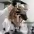 A scientist holds up a sample tube and looks at is closely