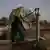 A woman drinks directly from a water well as temperatures soar above 48°C (118°F) during a heatwave in Daska, located in the Sialkot District of Punjab province, in Pakistan, June 10, 2025