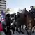 Um manifestante confronta policiais montados em cavalos nas ruas de Los Angeles, EUA