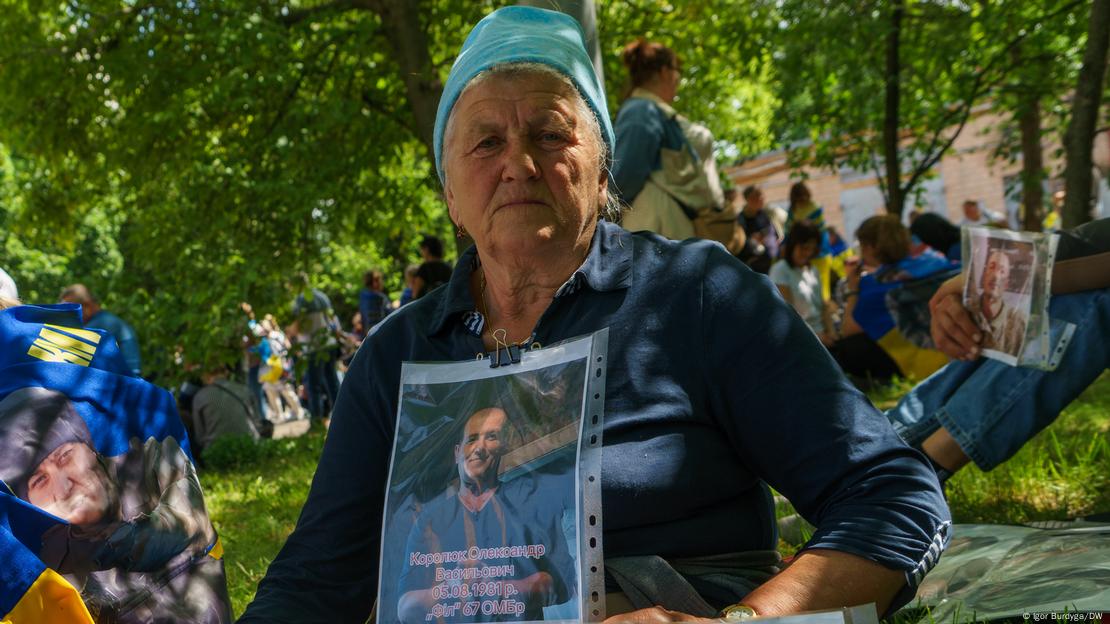 Пожилая женщина с фотографией сына, пропавшего в ходе войны в Украине