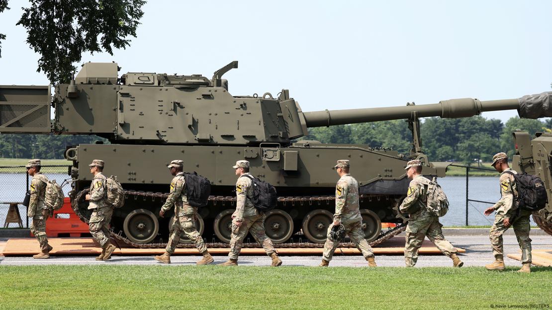Bir tank ve yanından yürüyerek geçen askerler