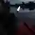 White signal flashlight in hand on the bow of an PVC inflatable motor boat, night floating safety without navigation lights on navigable river in dusk