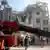 Rescue teams with heavy equipment stand in front of a destroyed building in Tehran