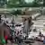 People gather near the site of a bridge collapse at Indrayani river near Kundamala village in Pune, India
