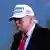 Porträt von US-Präsident Donald Trump im Profil und mit einer weißen Baseballkappe mit der US-amerikanischen Flagge und der dunkelblauen Aufschrift "Make America great again"