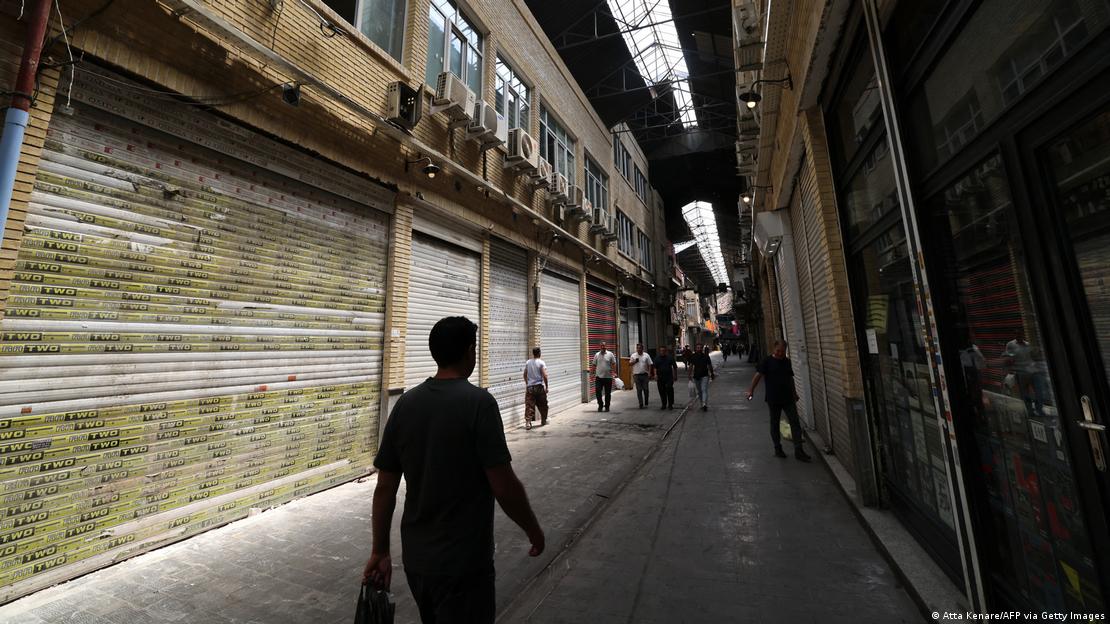 Homem anda em rua com comércios fechados