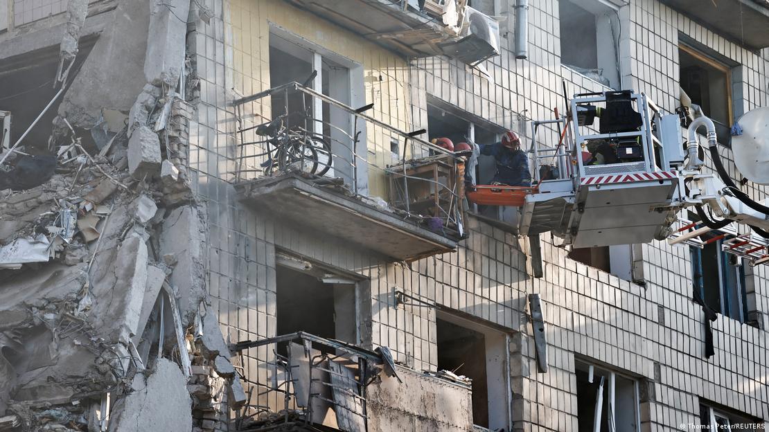 Ein zerstörtes Gebäude, Feuerwehrmänner mit einer Hebebühne an einem Fenster