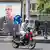 A man rides his motorbike past a portrait of slain Iranian armed forces chief of staff in Tehran