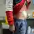 A young person stands, half-raising their sweatshirt, to show a bandage after an appendix operation