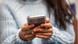 Mulher segura um smartphone Mulher segura um smartphone