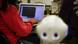 The image shows a student using a computer and a humanoid robot named Nova 