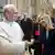 Pope Leo XIV (l) greets Italian Prime Minister Giorgia Meloni (r) at the Vatican with a handshake and a smile as several other people can be seen behind them