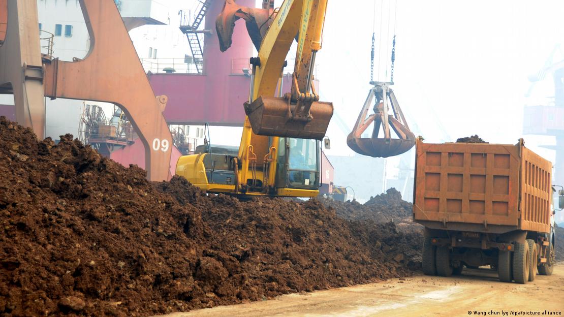 Çin'deki bir limanda nadir toprak elementi cevherini taşıyan kamyon ve vinçler