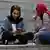 An Iranian woman looks into her cell phone while spending an afternoon on steps outside of a shopping mall in northern Tehran, Iran.
