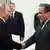 O presidente russo Vladimir Putin sorri e aperta a mão do ministro iraniano do Exterior, Abbas Araghchi no dia 23 de junho de 2025