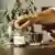 A businessman putting a tip in a jar on table at coffee shop