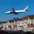 Eine British Airways Boeing 787-9 landet am Flughafen Heathrow, die Maschine fliegt in nahem Abstand über die Dächer einer Häuserreihe