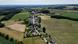Visão aérea do vilarejo de Grevels em Luxemburgo, com poucas casas ao redor de uma rua principal, cercada de campos Visão aérea do vilarejo de Grevels em Luxemburgo, com poucas casas ao redor de uma rua principal, cercada de campos
