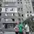 Residentes cerca de un edificio de apartamentos que resultó dañado durante un ataque con misiles rusos, en Dnipro, Ucrania, el 24 de junio de 2025.